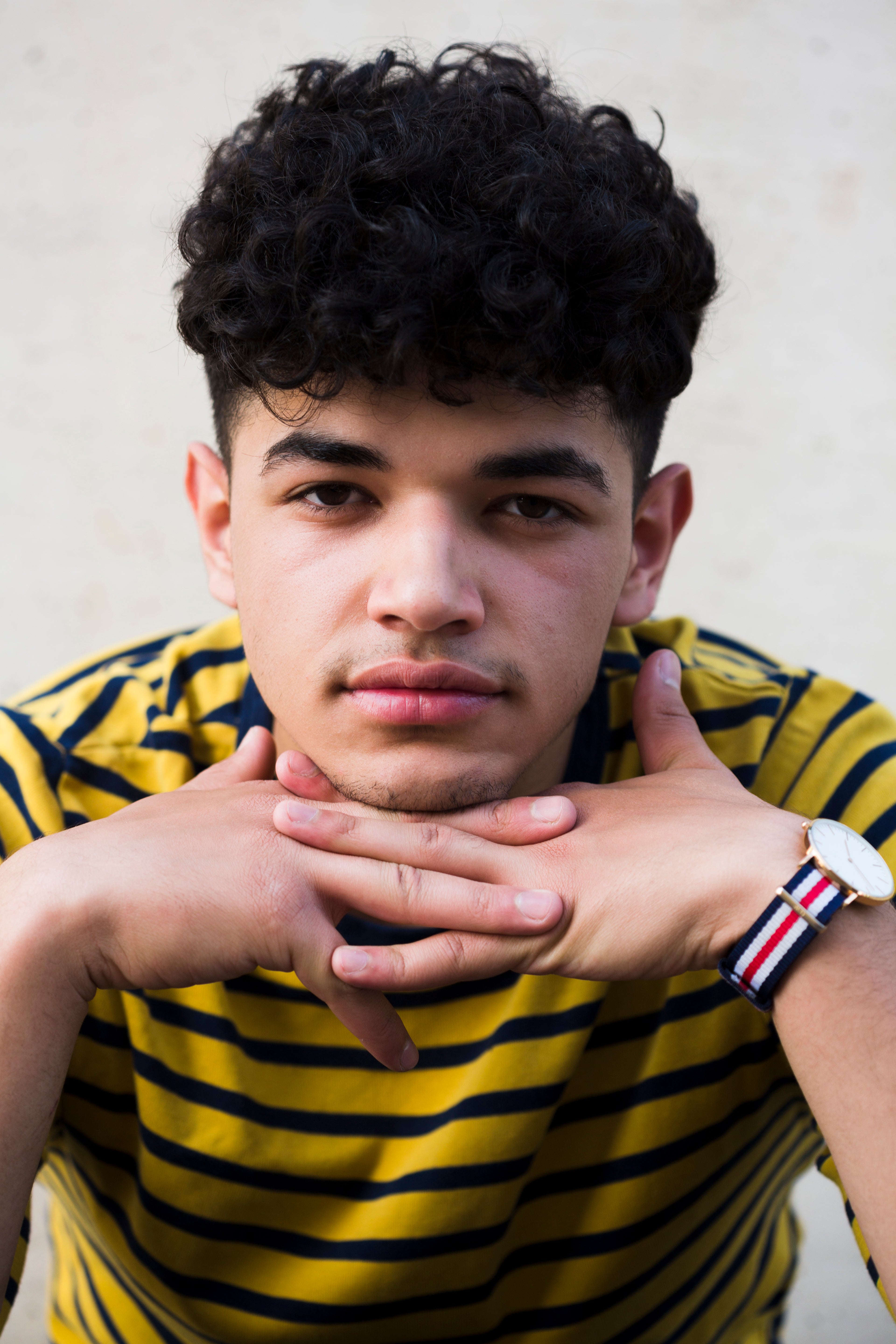 files/ethnic-young-man-with-curly-hair-leaning-hands.jpg